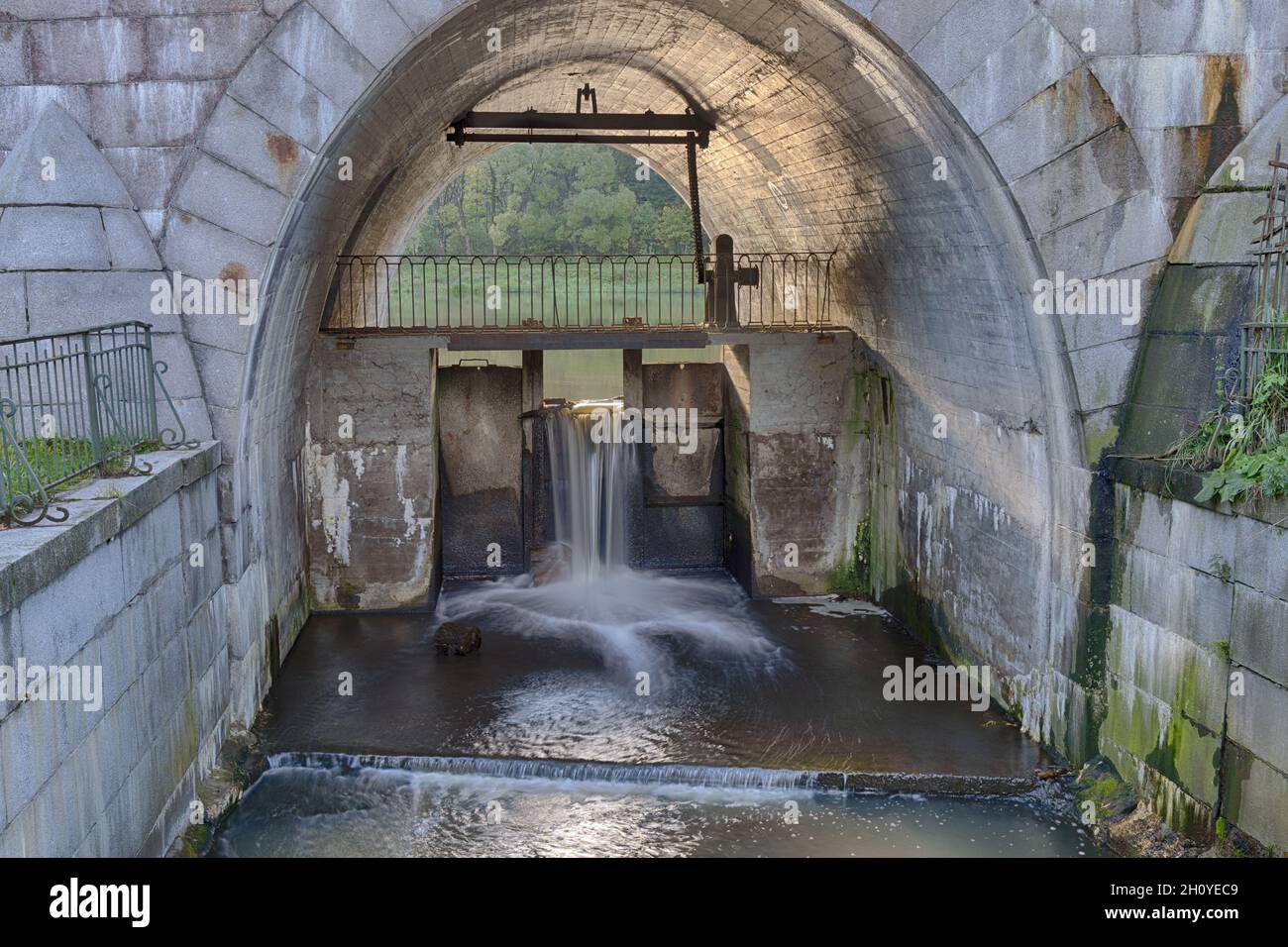 Ancienne écluse dans l'arche du pont avec un ruisseau d'eau (Pavlovsk, Saint-Pétersbourg, Russie) Banque D'Images