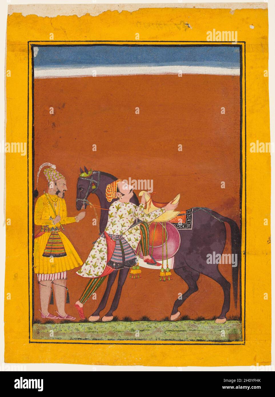 Un guerrier montant un cheval tenu: Saindhava Ragaputra de Shri, d'un Chamba Ragamala, c.1675. Nord de l'Inde, Himachal Pradesh, Pahari Royaume de Chamba.Gomme tempera et or sur papier; page: 25.7 x 18.8 cm (10 1/8 x 7 3/8 po.); image: 20.8 x 14.5 cm (8 3/16 x 5 11/16 po.).L'artiste a capturé la scène d'un noble guerrier qui monte sa direction.Vêtu d'un jama royal et d'un pantalon rayé, il place son pied gauche sur l'étrier car il tient les deux extrémités de la selle pour se soulever.Son marié se tient humblement derrière lui, en admirant la posture héroïque du guerrier. Banque D'Images