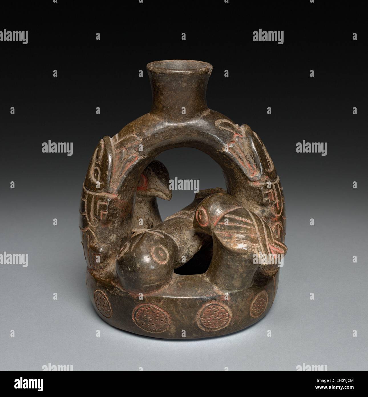 Navire avec figurine inclinable et oiseaux, 2200 - 200 C.-B.Andes, côte nord, style Cupisnique.Céramique, pigment (cinnabar?); hors tout : 14.3 x 14.9 cm (5 5/8 x 5 7/8 po).Ce vaisseau en céramique présente un être humain couché par deux oiseaux qui perchent dans la chambre en forme de beignet du navire.L'identité de la créature apparemment mythique modélisée en faible relief sur les côtés du bec en forme d'étrier est inconnue.On ne peut pas dire grand chose au sujet de la signification au-delà de la référence évidente à la mort. Banque D'Images Navire avec figurine inclinable et oiseaux, 2200 - 200 C.-B.Andes, côte nord, style Cupisnique.Céramique, pigment (cinnabar?); hors tout : 14.3 x 14.9 cm (5 5/8 x 5 7/8 po).Ce vaisseau en céramique présente un être humain couché par deux oiseaux qui perchent dans la chambre en forme de beignet du navire.L'identité de la créature apparemment mythique modélisée en faible relief sur les côtés du bec en forme d'étrier est inconnue.On ne peut pas dire grand chose au sujet de la signification au-delà de la référence évidente à la mort. Banque D'Images