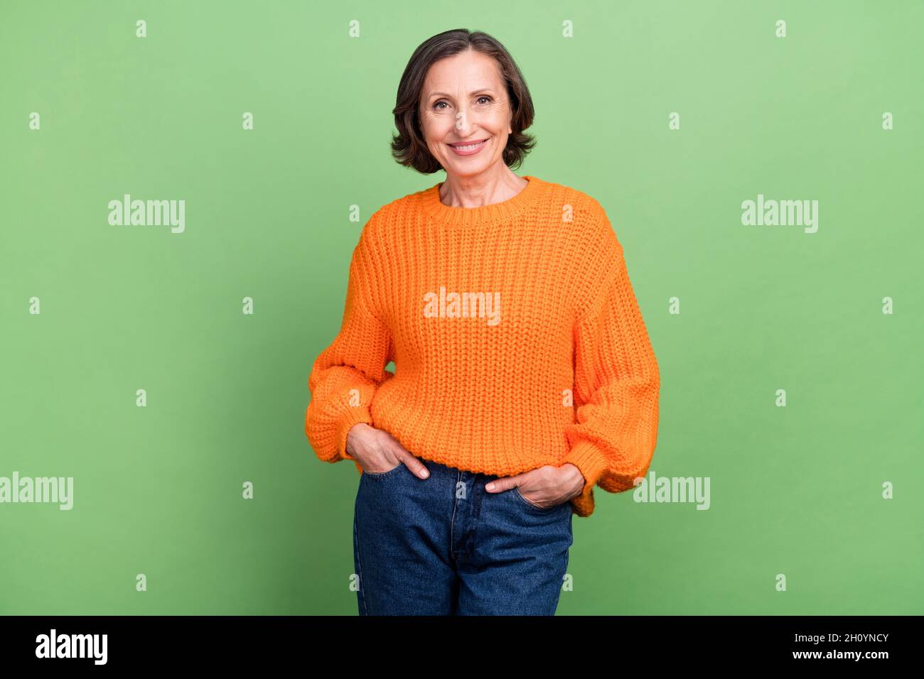 Photo d'un grand-mère sympa et cool mains dans la poche bonne humeur tenue décontractée isolée sur fond vert couleur Banque D'Images