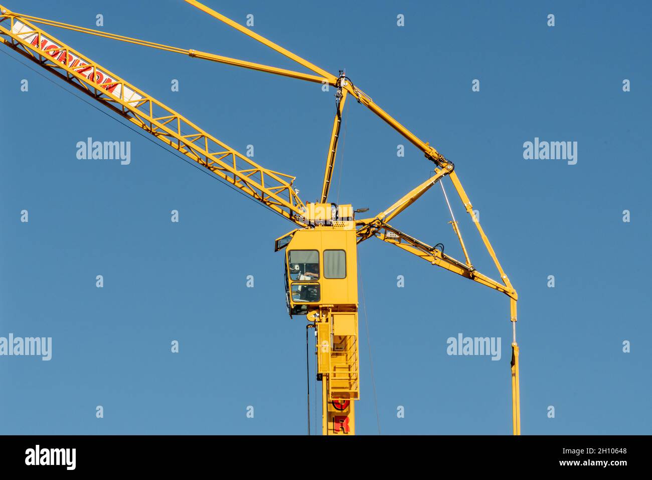 Une grue à tour jaune est en service à Glasgow sur fond bleu clair Banque D'Images