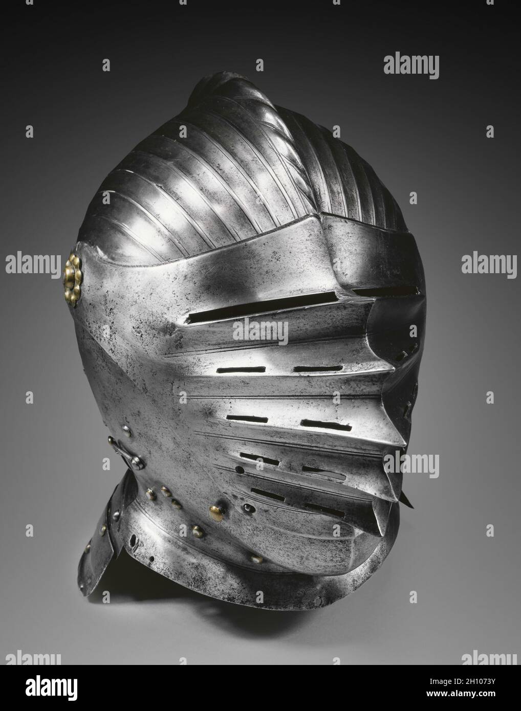 Fermer Helmet dans le style Maximilien, c.1520. Allemagne, XVIe siècle.Acier et laiton; hors tout : 30.5 x 21.8 x 32 cm (12 x 8 9/16 x 12 5/8 po).Le muting régulier de ce casque est un style connu sous le nom de 'Maximilian', nommé d'après Maximilian I, Saint empereur romain (1493-1519).En plus d'être décoratif, la bride est un dispositif de renforcement qui fonctionne comme le métal ondulé.Cette décoration aurait été coûteuse car elle prenait beaucoup de temps à produire et nécessitait un travail précis.Il n'aurait été disponible que pour les clients les plus riches. Banque D'Images