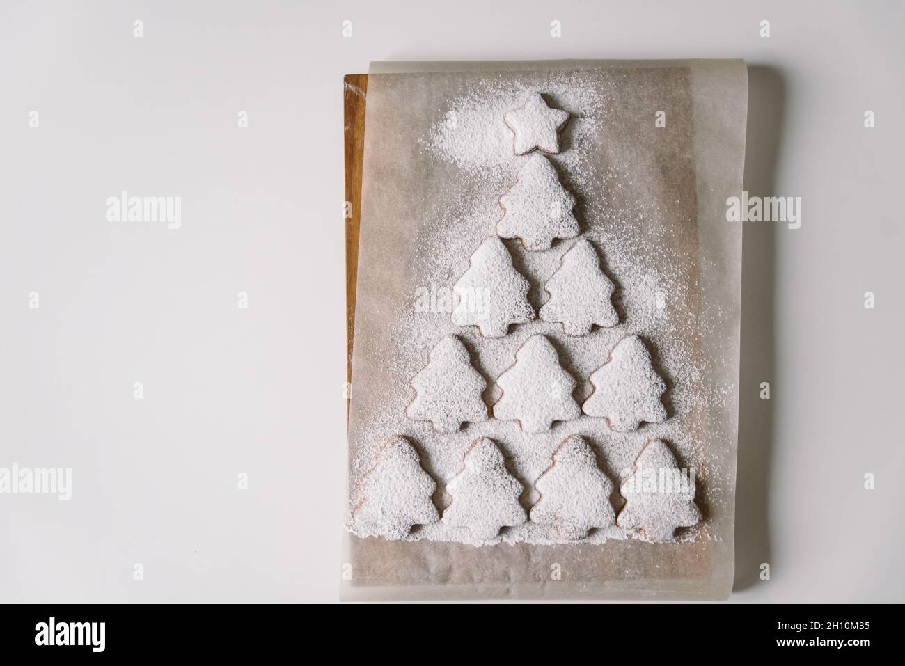 Arbre de Noël en pain d'épice parsemé de sucre en poudre sur parchemin Banque D'Images