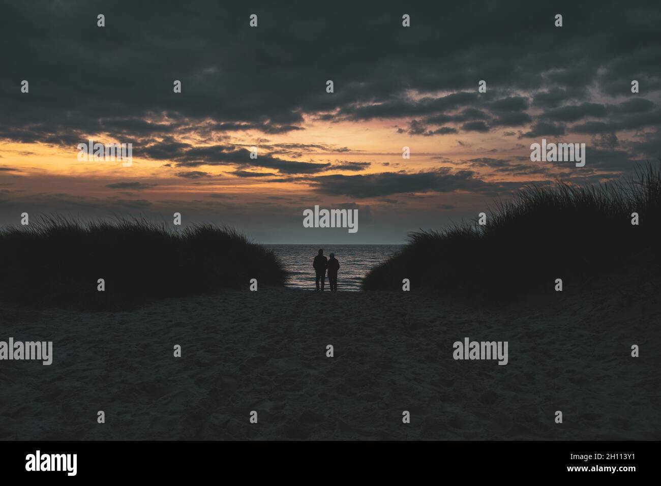 Couple sur la plage au coucher du soleil Banque D'Images