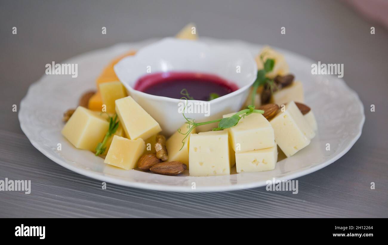 Différents types de fromage avec sauce, morceaux de fromage et sauce sur une assiette dans un restaurant. Banque D'Images
