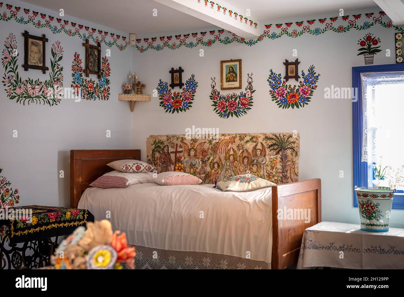 Zalipie, Pologne - 1er août 2021 : intérieur d'un chalet traditionnel en bois.Mobilier vintage, motifs floraux sur le mur. Banque D'Images