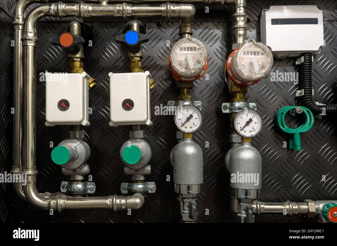 Conduites d'eau, vannes et manomètres à l'intérieur de la maison, système avec pompes et chauffages électriques.Canalisation métallique de la chaudière domestique, tubes froids et chauds sur le réseau Banque D'Images