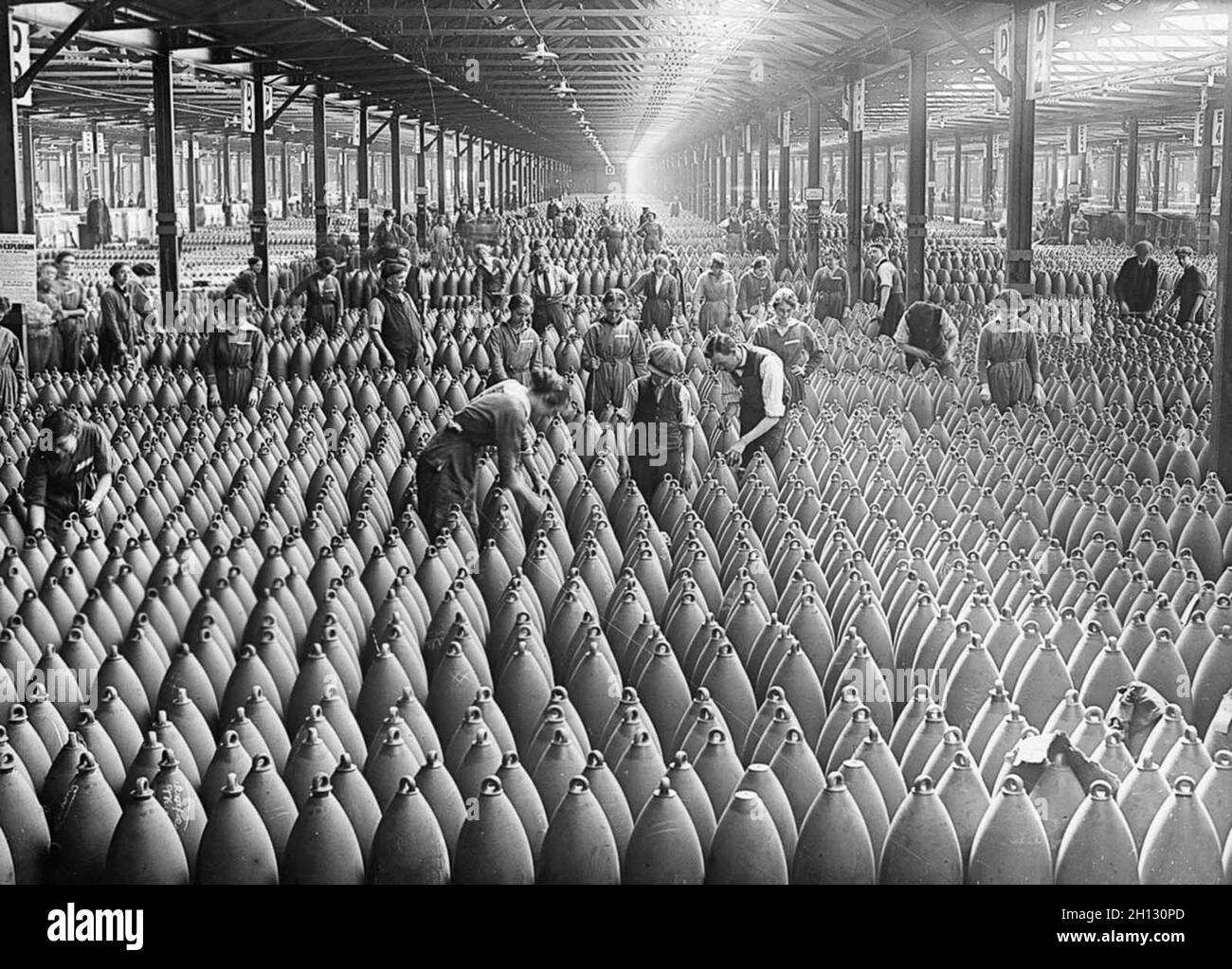 Des femmes et des hommes travaillent dans les rangs de obus d'artillerie à la National Filling Factory de Chilwell.1917. Banque D'Images