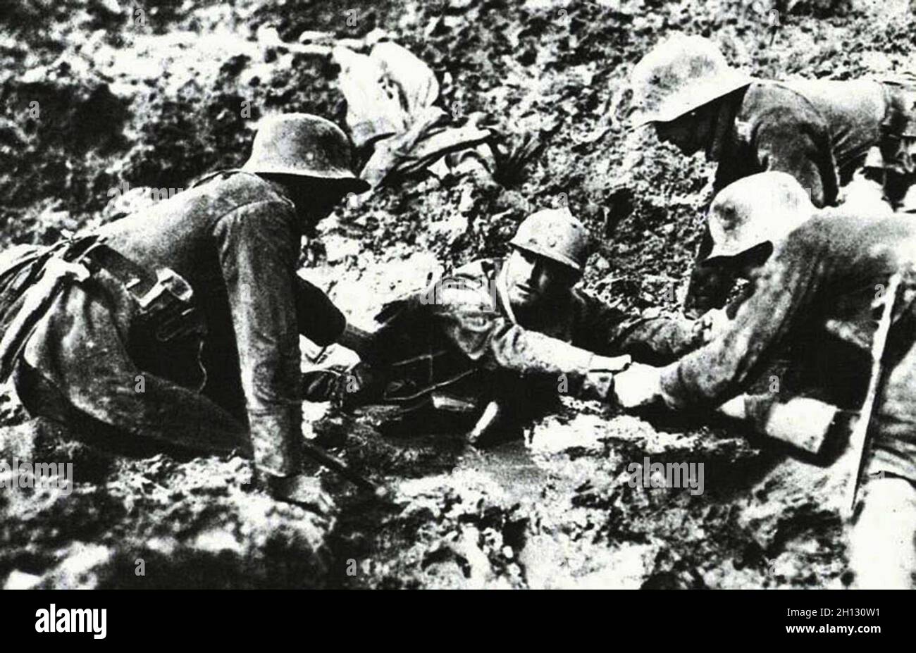 Les troupes allemandes qui tentent de sauver un soldat français du naufrage dans un trou de boue, 1918. Banque D'Images