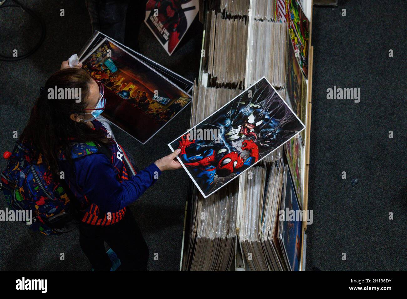 Un gardien de l'événement ramasse une affiche de 'Venom et Spiderman' au cours du premier jour du SALON SOFA (salon del Ocio y la Fantasia) 2021, une foire destinée au public geek en Colombie qui mêle cosplay, les jeux, le super-héros et les fans de cinéma de toute la Colombie, à Bogota,Colombie le 14 octobre 2021. Banque D'Images