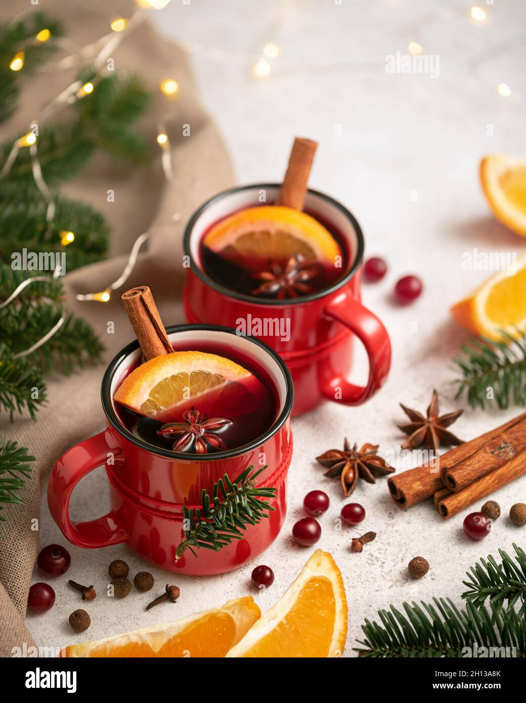 Vin chaud dans une tasse rouge près de l'arbre de Noël et des lumières Banque D'Images