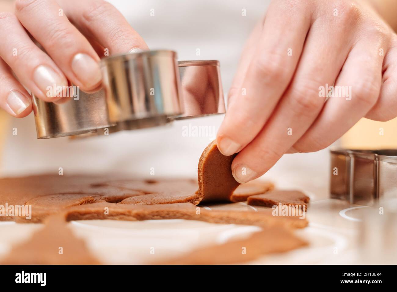 Femme coupant des petits hommes de la pâte de gingembre dans un moule. Banque D'Images