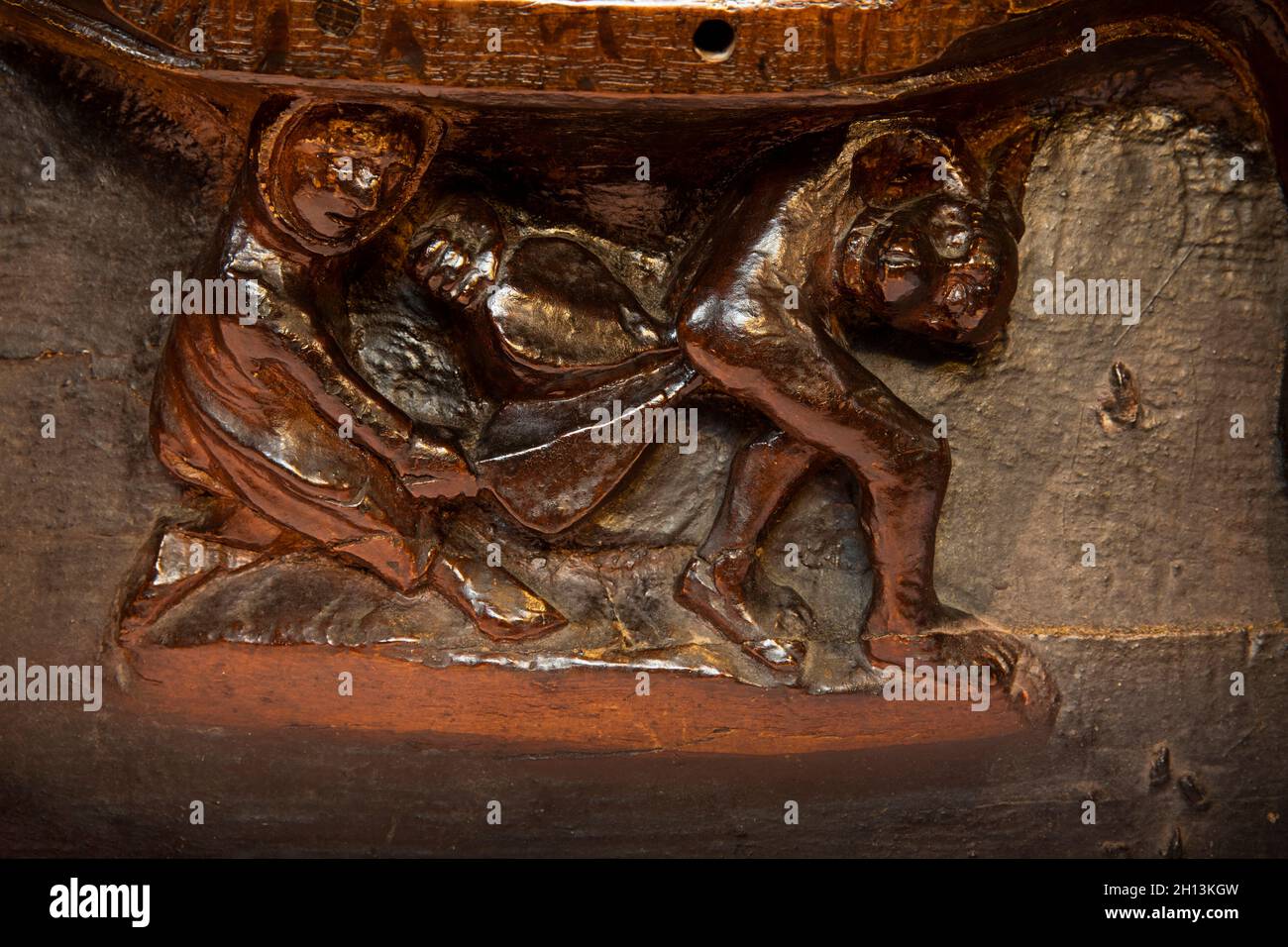 Royaume-Uni, Angleterre, Worcestershire, Great Malvern, Église du Prieuré,Quire, C15th médiéval Misericord, femme avec le soufflet traitant mari ivre (avec lui de taureau Banque D'Images