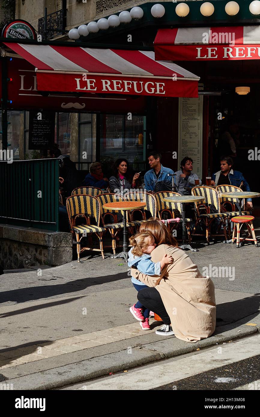 Paris, France - juin 2019 : une femme porte son enfant dans la rue, en face de la station de métro Lamarck-Colaincourt à Montmartre l'été. . O Banque D'Images