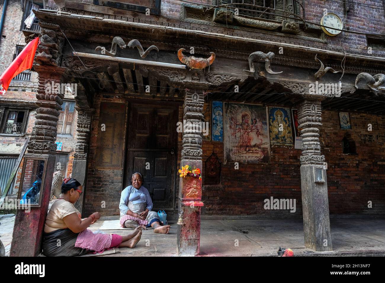 Bhaktapur, Népal - octobre 2021 : les femmes sont assises à côté d'images de dieux hindous à Bhaktapur le 9 octobre 2021 dans la vallée de Katmandou, Népal. Banque D'Images