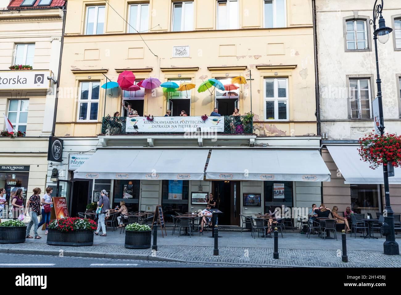 Varsovie, Pologne - 1er septembre 2018 : Nowy Swiat, rue commerçante avec un bar avec parasols multicolores et des boutiques et des gens autour dans la vieille ville de Banque D'Images