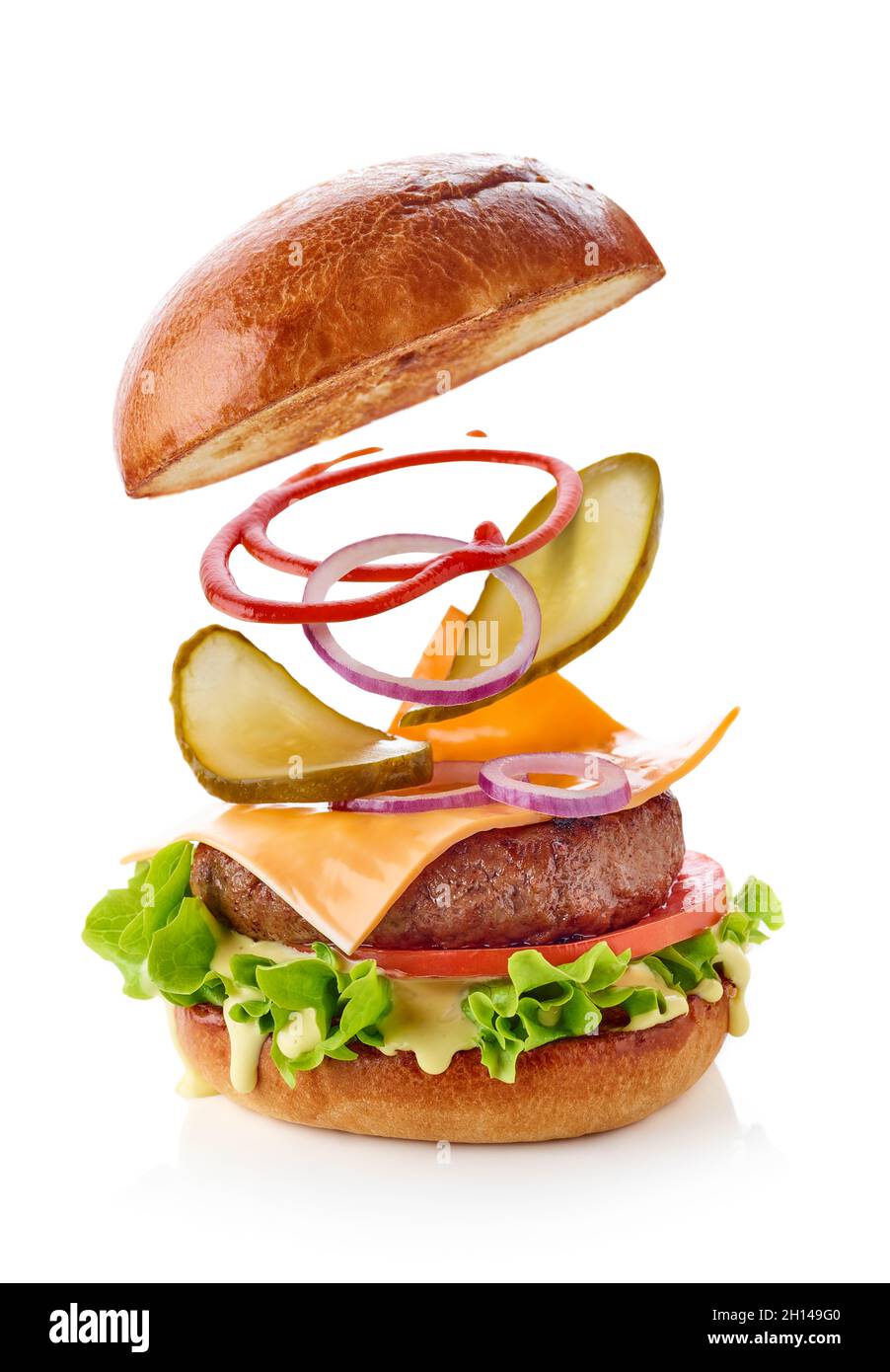 Hamburger avec ingrédients volants isolés sur fond blanc Banque D'Images