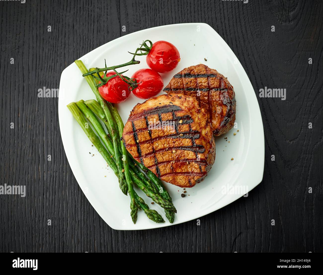Steak de veau fraîchement cuit sur une assiette blanche, vue sur le dessus Banque D'Images