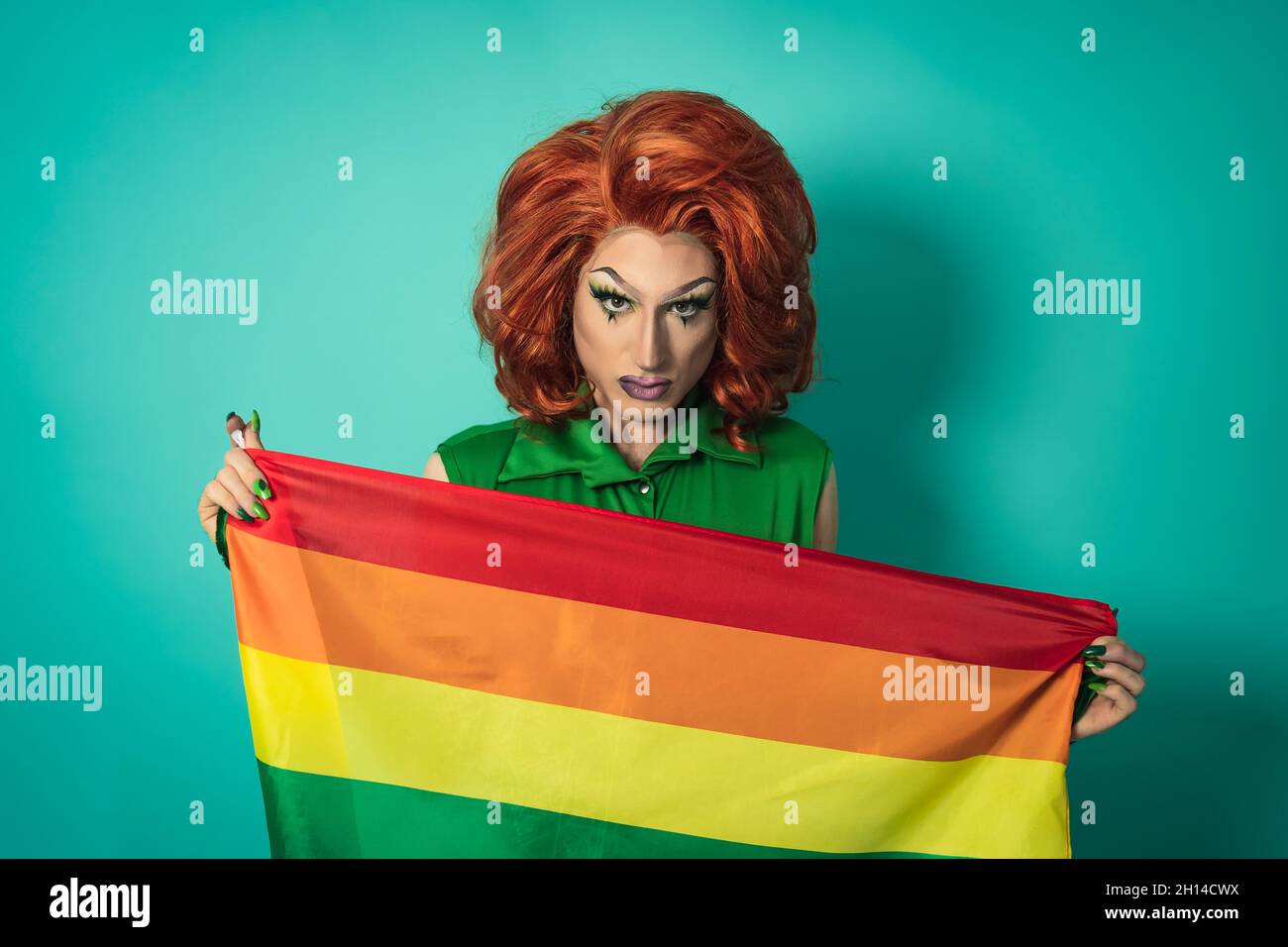 Drag queen célébrant la fierté gay tenant le drapeau arc-en-ciel - concept de communauté sociale LGBTQ Banque D'Images