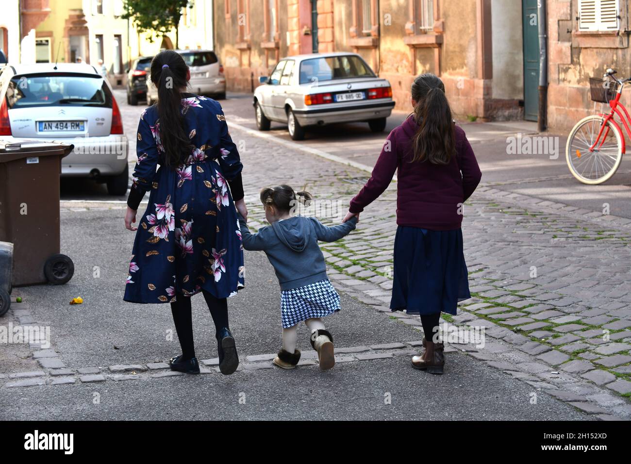 Les filles marchant dans la rue en tenant les mains Banque D'Images