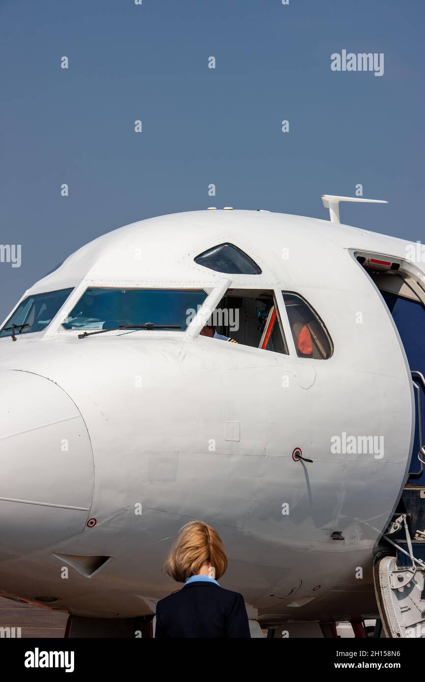 Hôtesse de l'air entrant dans l'avion, vue extérieure Banque D'Images