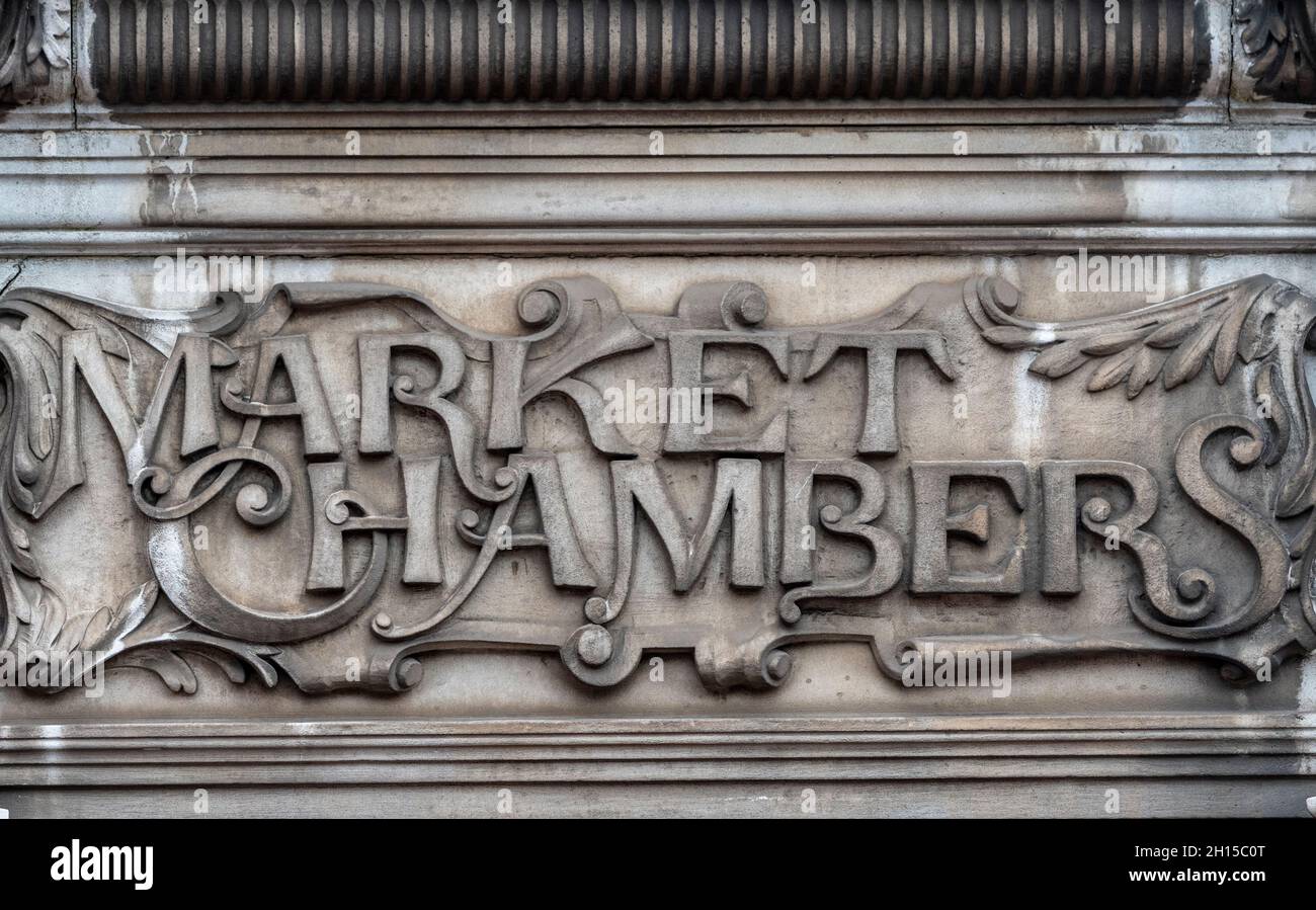 panneau architectural historique dans le style art nouveau d'écriture fluide organique ou de script sculpté dans la pierre au-dessus d'une porte d'époque des chambres de marché. Banque D'Images