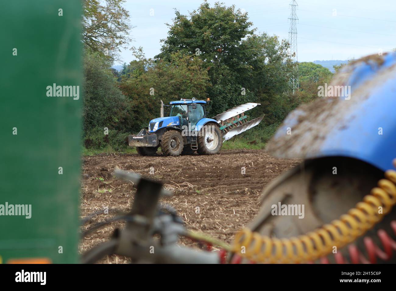Tracteur Blue New Holland T7060 (2009) avec charrue à socs 5 réversibles Banque D'Images
