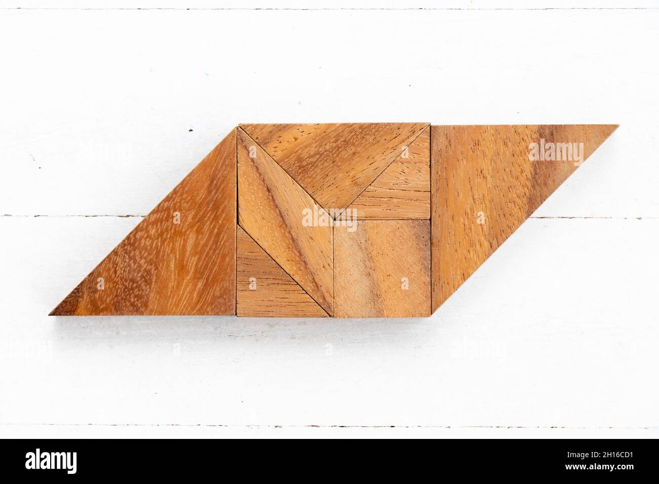 Puzzle en bois en forme de parallélogramme sur fond de bois blanc Banque D'Images