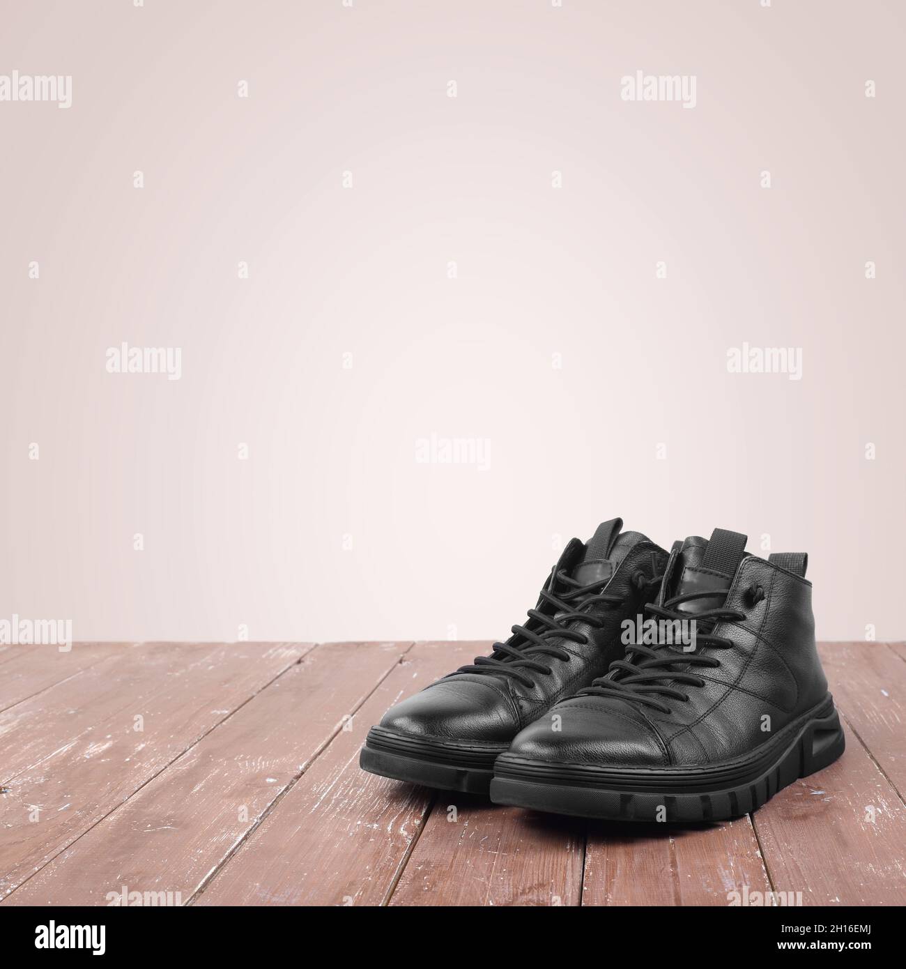 Vêtements chaussures et accessoires - vue de face bottes d'hiver neuves noires sur fourrure sur fond en bois Banque D'Images