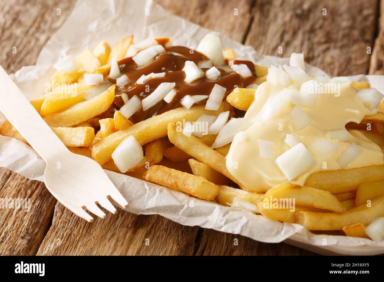 Patatje oorlog est un plat hollandais composé de frites nappées d'une mayonnaise, d'oignons finement hachés et d'une sauce aux arachides dans l'assiette o Banque D'Images