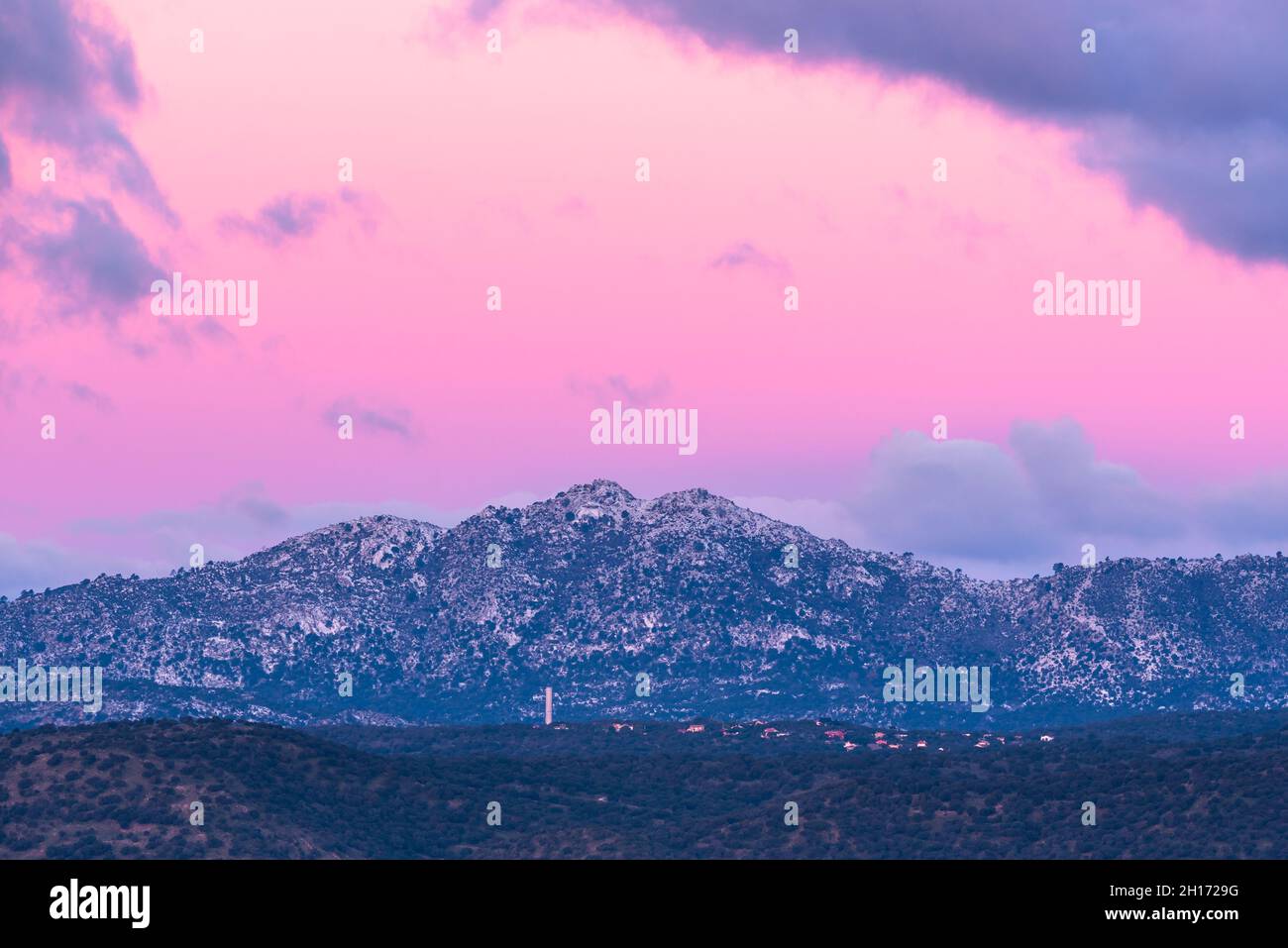 Paysage à couper le souffle de la chaîne de montagnes rocheuses et de la vallée avec des arbres verts sous le ciel de soleil rose avec des nuages dans le parc national de la Sierra de Guadarrama en S Banque D'Images