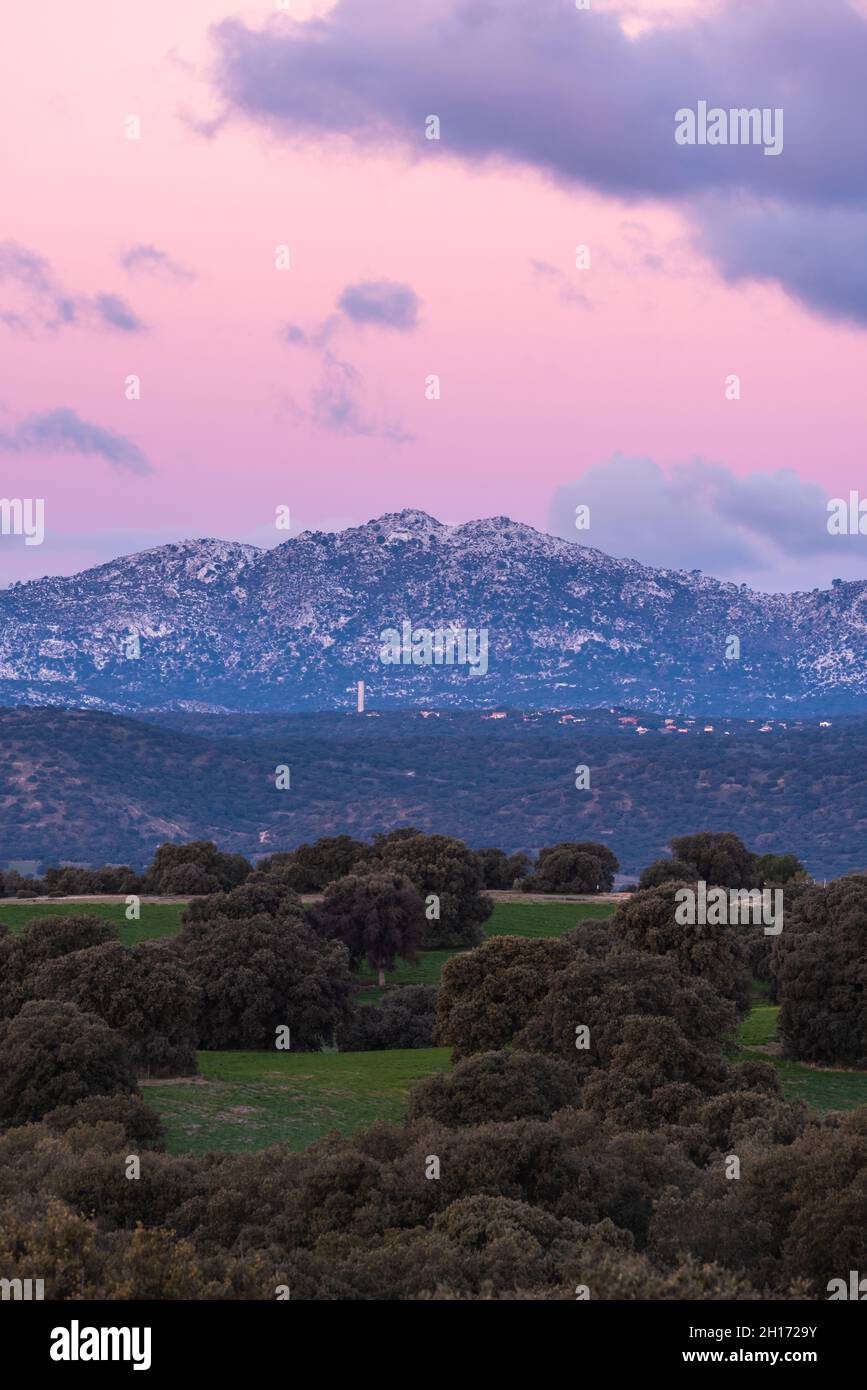 Paysage à couper le souffle de la chaîne de montagnes rocheuses et de la vallée avec des arbres verts sous le ciel de soleil rose avec des nuages dans le parc national de la Sierra de Guadarrama en S Banque D'Images