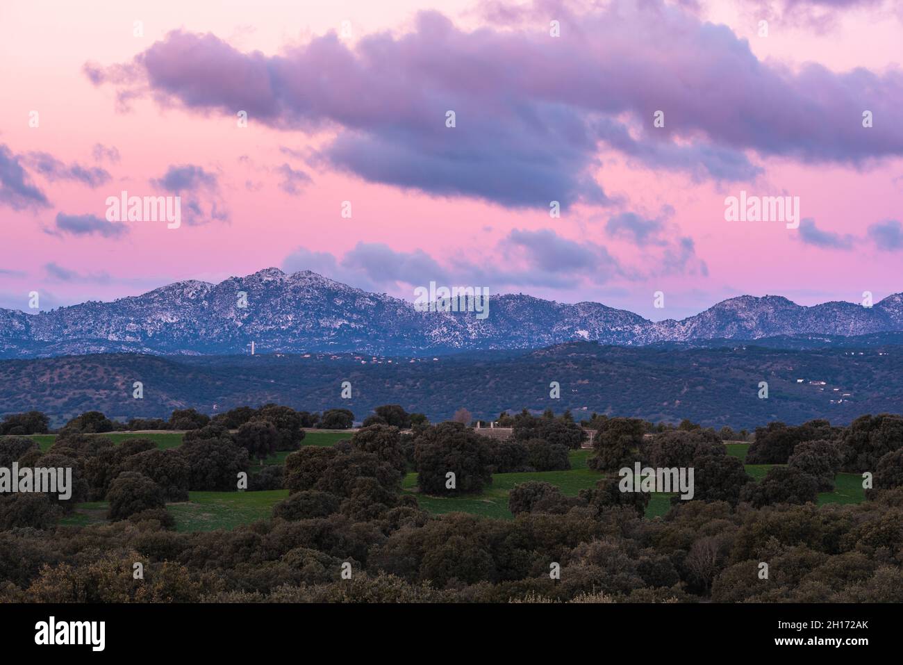 Paysage à couper le souffle de la chaîne de montagnes rocheuses et de la vallée avec des arbres verts sous le ciel de soleil rose avec des nuages dans le parc national de la Sierra de Guadarrama en S Banque D'Images