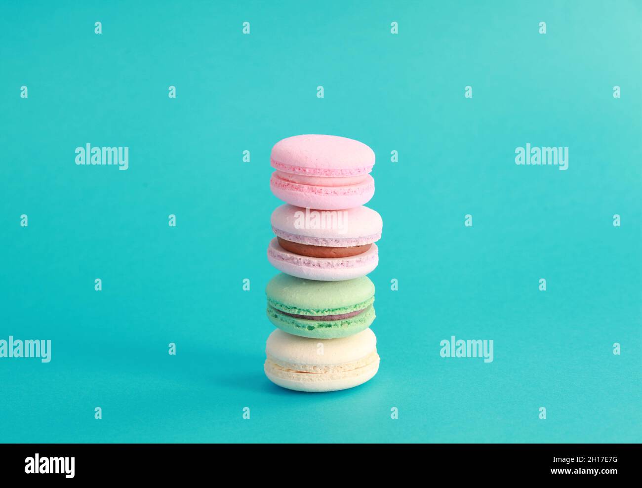 Macaron ou macaron sur fond turquoise, biscuits aux amandes colorés avec différentes garnitures Banque D'Images