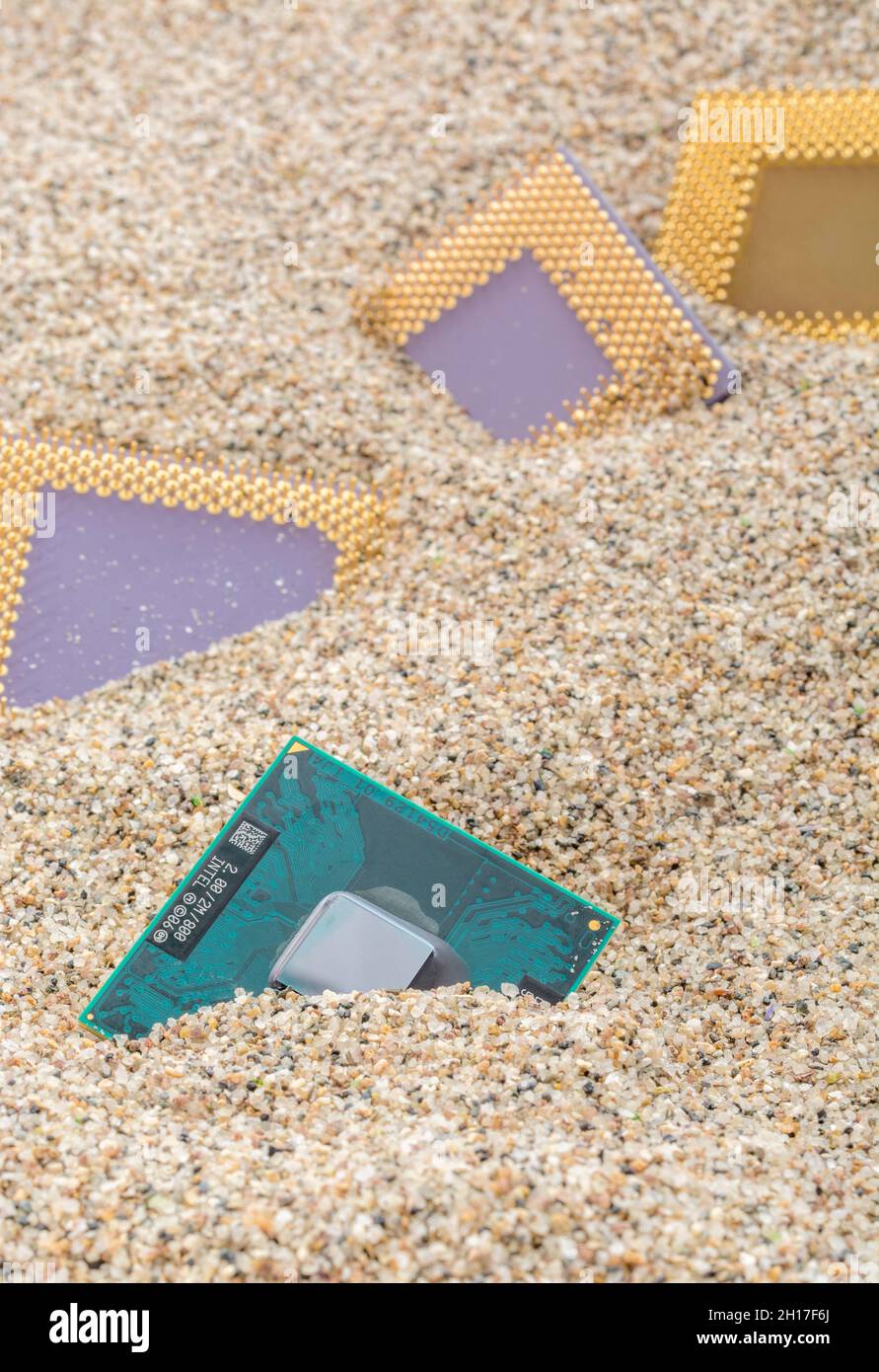 Anciens processeurs informatiques enfouis dans un tas sablonneux pour le cimetière informatique, l'informatique héritée.Processeurs Intel Merom, AMD Sempron, AMD Duron et K6 présents. Banque D'Images