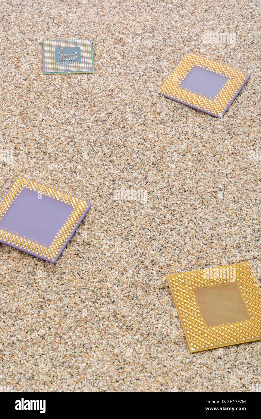 Anciens processeurs informatiques enfouis dans un tas sablonneux pour le cimetière informatique, l'informatique héritée.Processeurs Intel Merom, AMD Sempron, AMD Duron et K6 présents. Banque D'Images