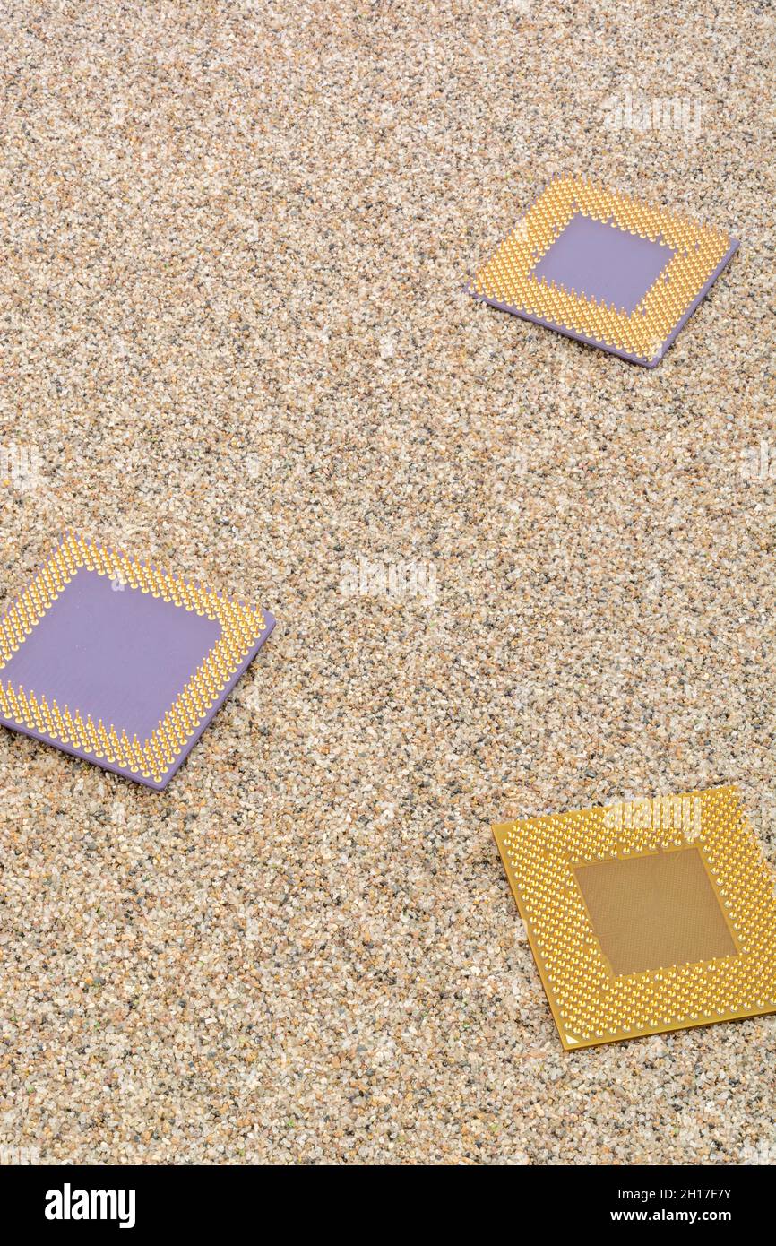 Anciens processeurs informatiques enfouis dans un tas sablonneux pour le cimetière informatique, l'informatique héritée.Processeurs AMD Sempron, AMD Duron et K6 présents. Banque D'Images