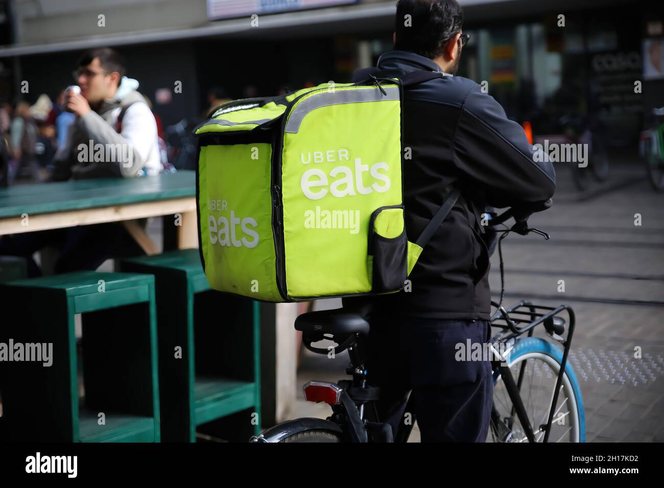 Gand, Belgique - octobre 9.2021: Gros plan de uber Eats personne de service de livraison de la nourriture sur le vélo avec le sac vert à dos dans le centre-ville (se concentrer sur l'avant de Banque D'Images