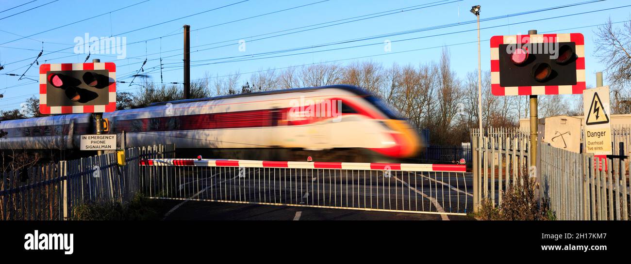 Train Azuma passant les feux rouges à un passage à niveau sans pilote, East Coast main Line Railway, Peterborough, Cambridgeshire, Angleterre, Royaume-Uni Banque D'Images