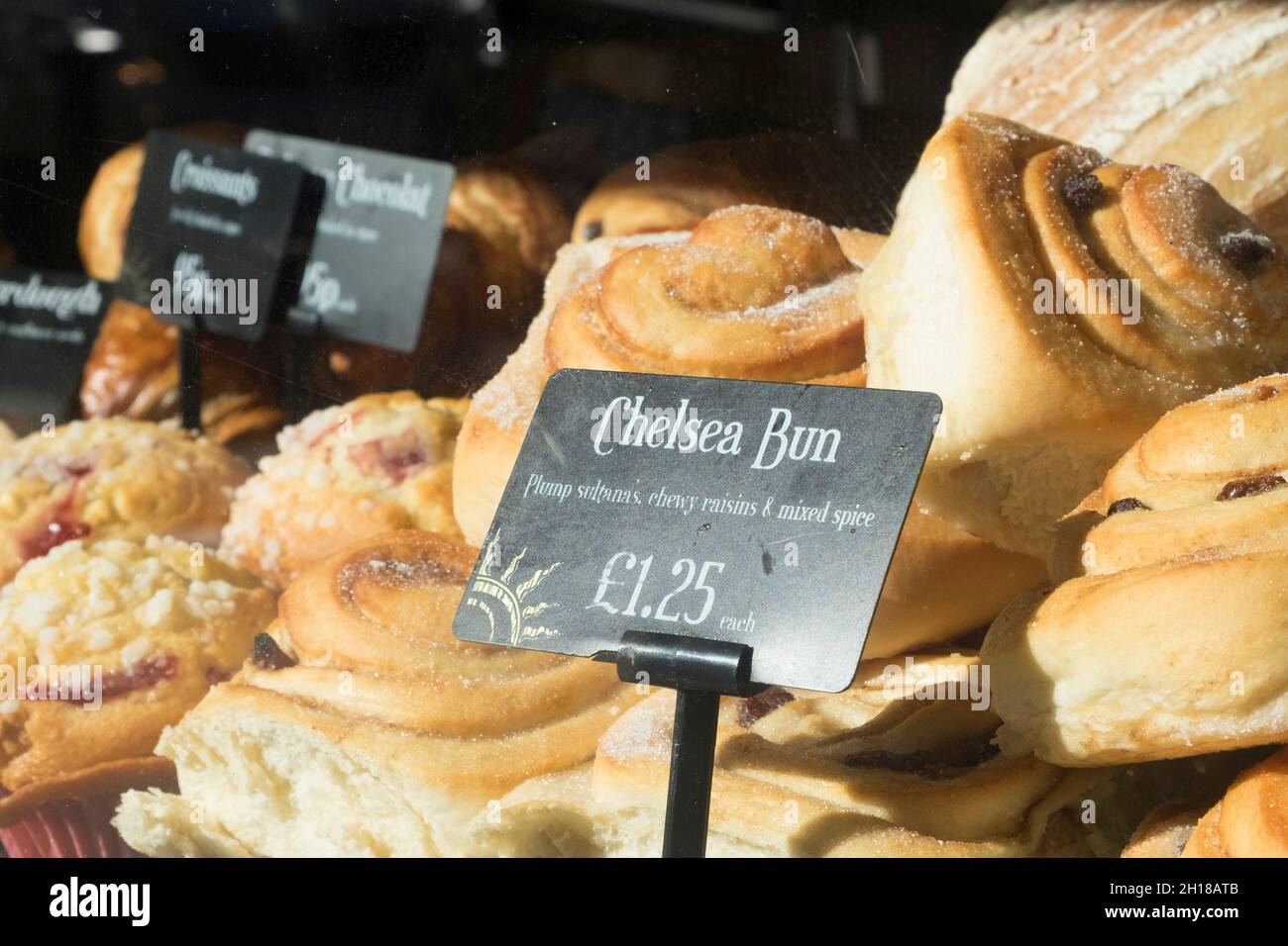 Des petits pains Chelsea dans une fenêtre de la boutique de boulangers Banque D'Images