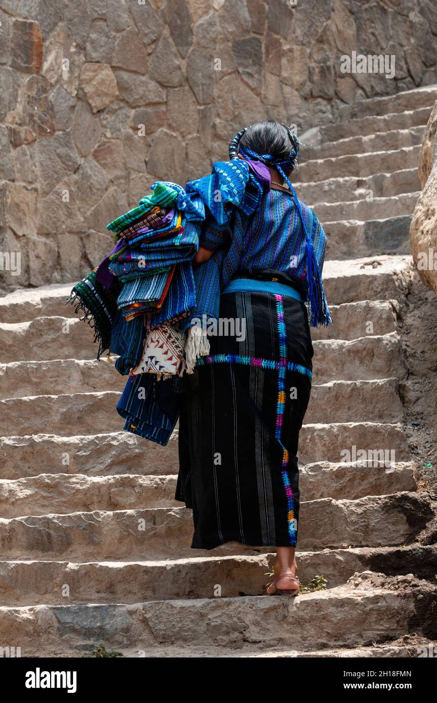 Une femme en robe traditionnelle grimpant des marches de pierre abruptes.San Antonio Palopo, Solola, Guatemala. Banque D'Images