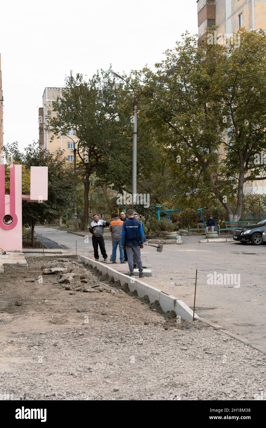 Tiraspol, Moldova - 15 octobre 2021 : les travailleurs des services routiers installent de nouvelles bordures en béton dans la cour d'un immeuble d'appartements dans la capitale du Banque D'Images