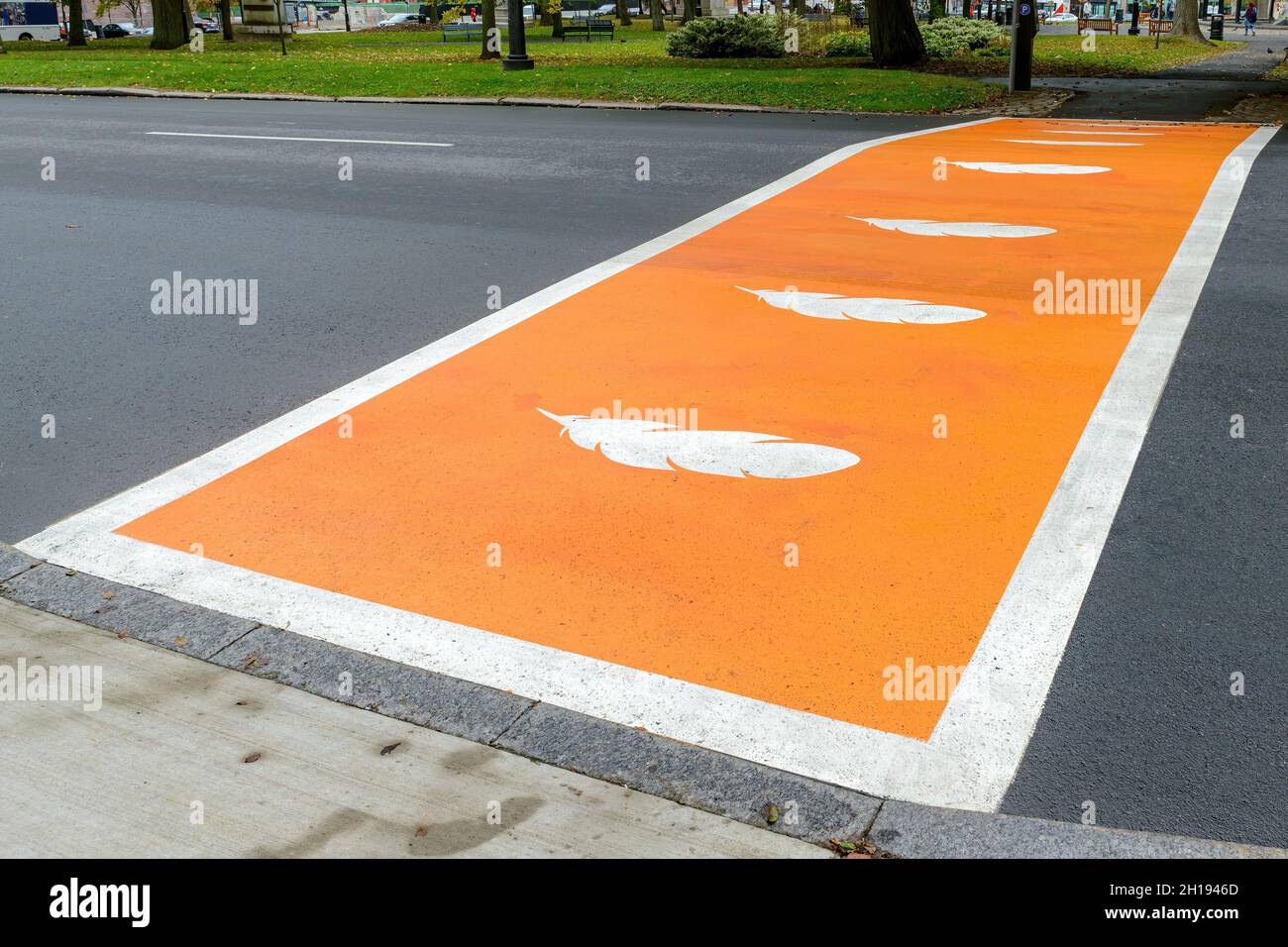 La craie peinte en orange avec des plumes blanches pour la vérité et la réconciliation afin d'honorer les enfants autochtones qui sont morts dans les pensionnats du Canada. Banque D'Images