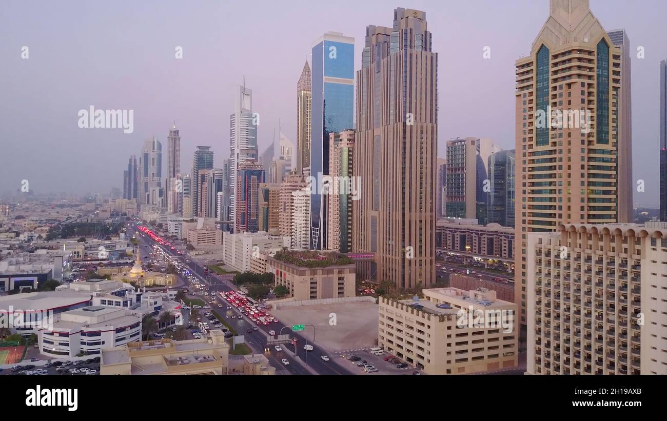 Vue sur les gratte-ciels modernes et les autoroutes animées le soir dans le centre-ville de luxe de Dubaï.Vue aérienne supérieure depuis le toit de la tour.Circulation aux intersections. Banque D'Images