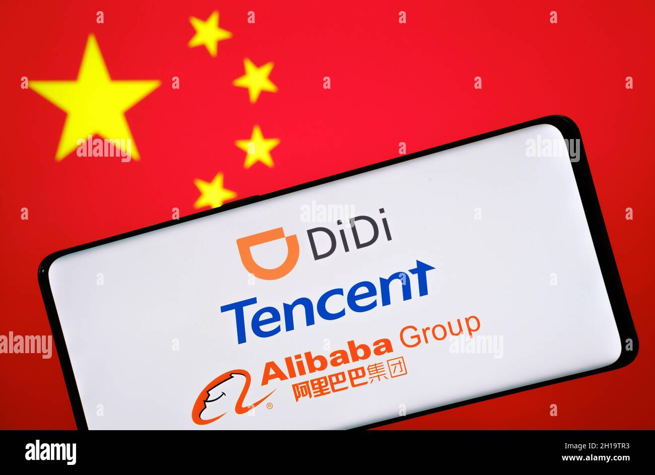 Chinois BigTech concept.Didi, Tencent, Alibaba logos vus sur smartphone et drapeau flou de la Chine sur le fond.Stafford, Royaume-Uni, octobre Banque D'Images