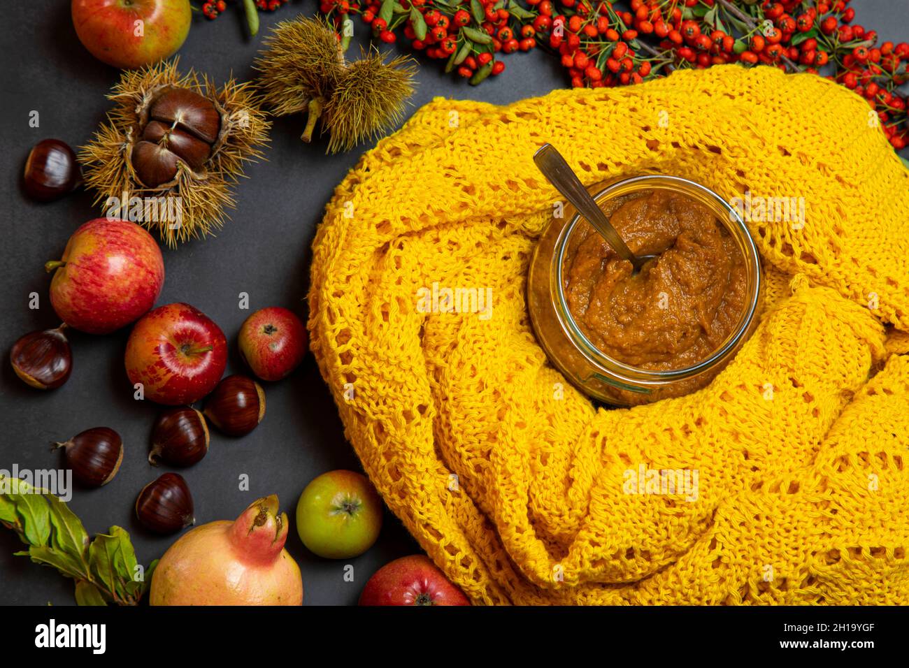 soupe de potiron sur fond noir, décorée de châtaignes jaunes, de pommes, de grenade, de baies sauvages orange Banque D'Images