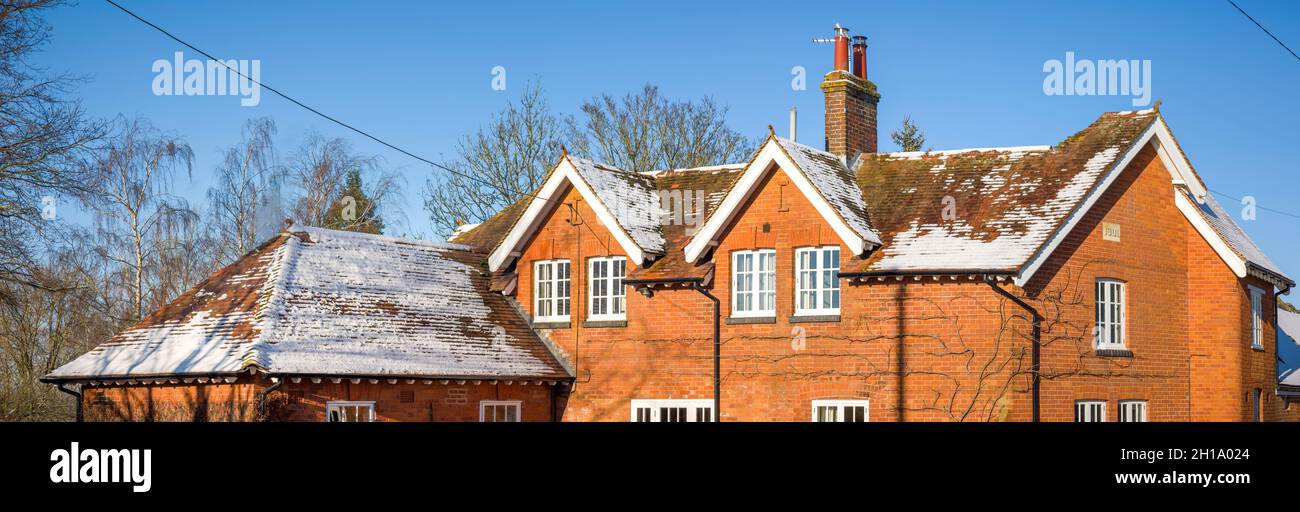 Neige sur le toit incliné d'une maison d'époque du Royaume-Uni en hiver, avec des fenêtres de remplacement en bois à double vitrage.Scène panoramique Banque D'Images