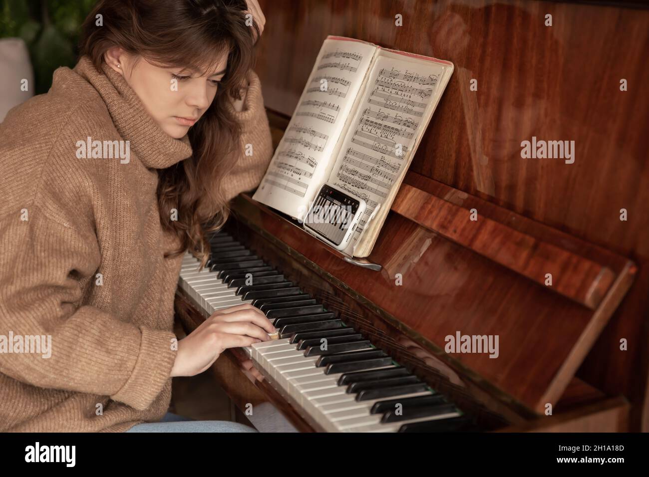 Une femme apprend à jouer du piano à l'aide d'une application sur son  téléphone Photo Stock - Alamy