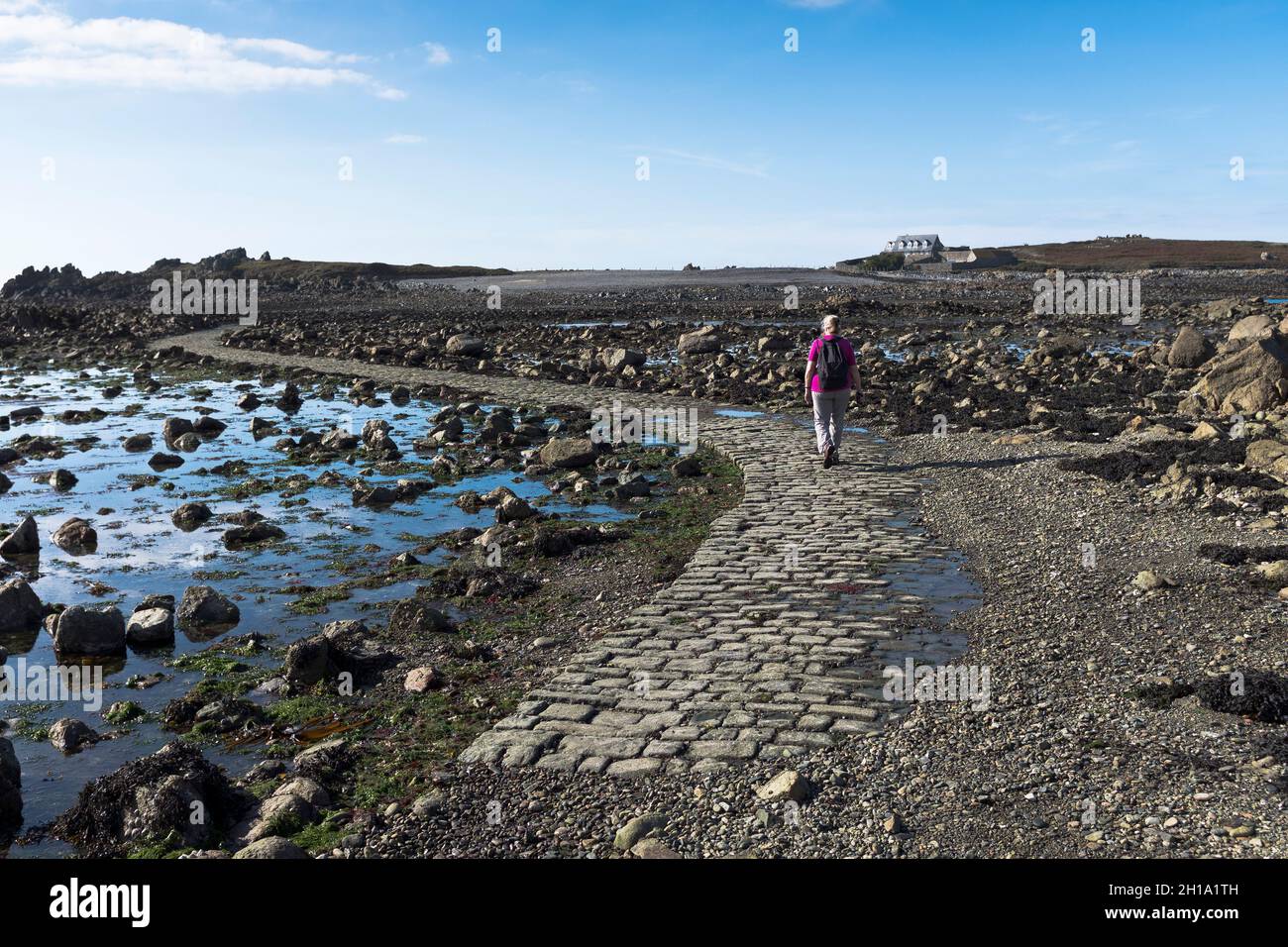 dh LIHOU ISLAND GUERNESEY femme touriste marchant sur la chaussée pour les habitants des îles Banque D'Images