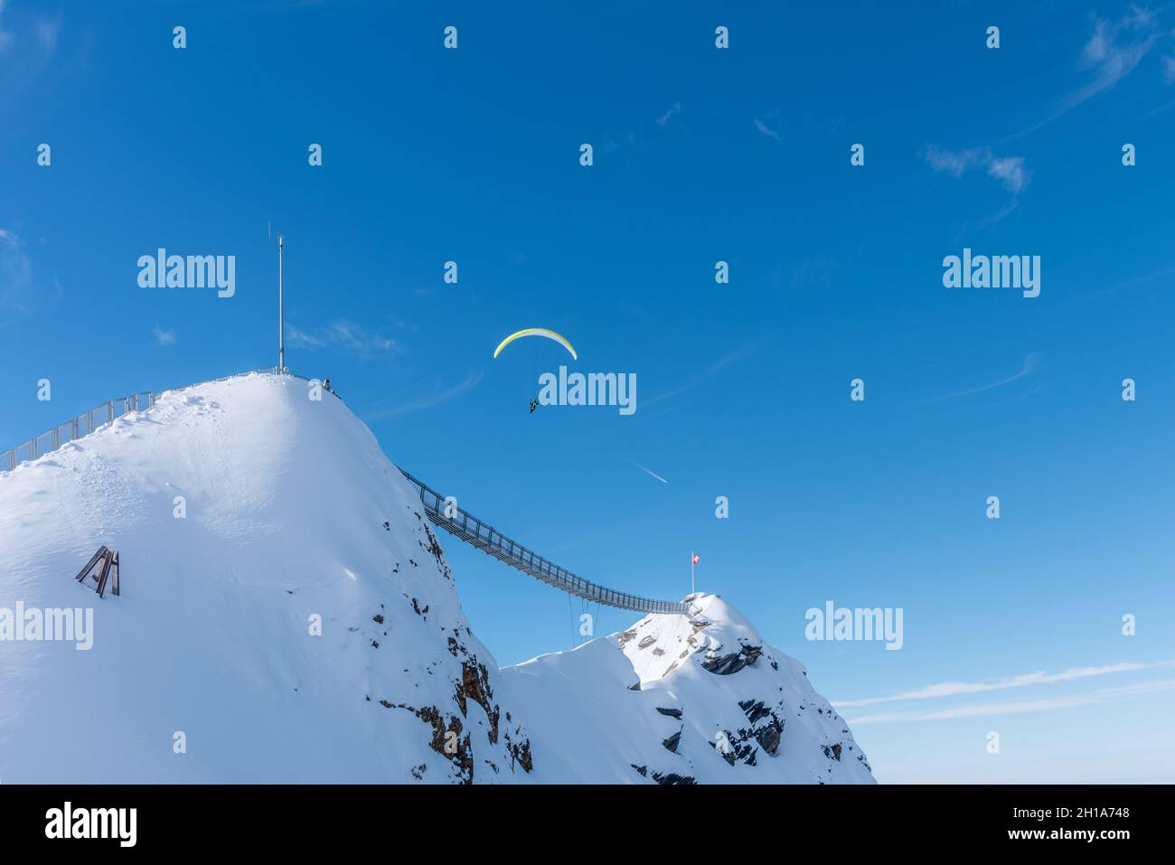 Deux montagnes avec pont suspendu les reliant à une personne dans le ciel parapente au-dessus de Diablerets Glacier 3000 Banque D'Images